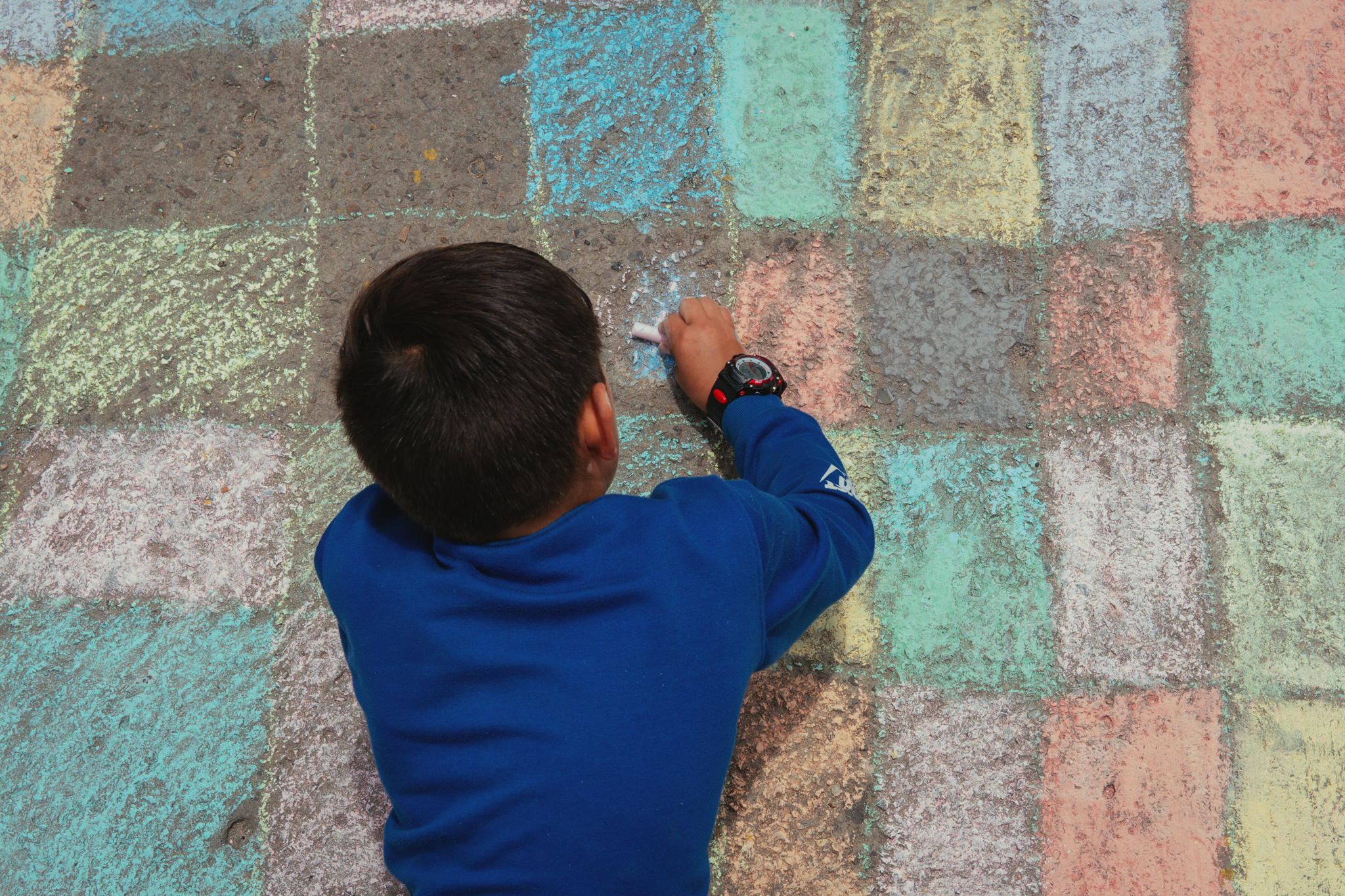 Fotografía de niño pintando con tiza de colores